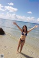 A woman in a blue bikini standing in the water.