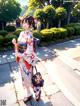 A woman in a kimono walking down a sidewalk.