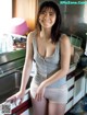 A woman standing in a kitchen next to a sink.