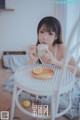 A woman sitting at a table with a cup of coffee.