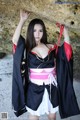 A woman in a black and pink kimono posing for a picture.