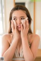 A woman wiping her face with a tissue.