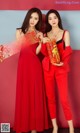 Two women in red dresses posing for a picture.