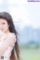 A woman with long black hair standing in a field.