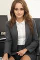 A woman in a business suit sitting at a desk.