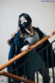 A woman wearing a face mask standing on a stairwell.