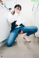 A woman sitting on the floor in a kitchen.