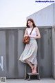 A woman standing on top of a ladder next to a wall.