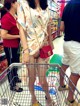 A woman in a shopping cart in a store.