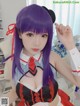 A woman with purple hair wearing a maid outfit.