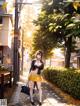 A woman in a yellow skirt is walking down the street.