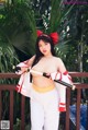 A woman in a red and white outfit holding a sword.