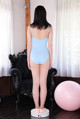 A woman in a blue bodysuit standing on a scale.