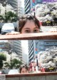 A woman peeking over a wall in the middle of a city.