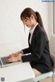 A woman sitting at a desk using a laptop computer.