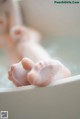 A baby's feet in a bathtub with bubbles.