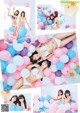 A group of young women in bikinis laying on a bed of balloons.